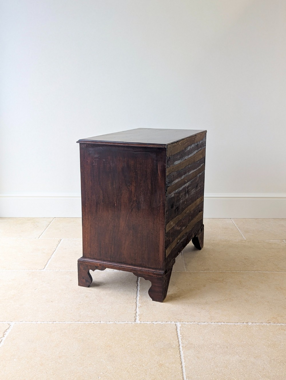 An 18th-century George III mahogany chest of drawers featuring four graduated drawers with brass swan-neck handles and bracket feet. View XVI