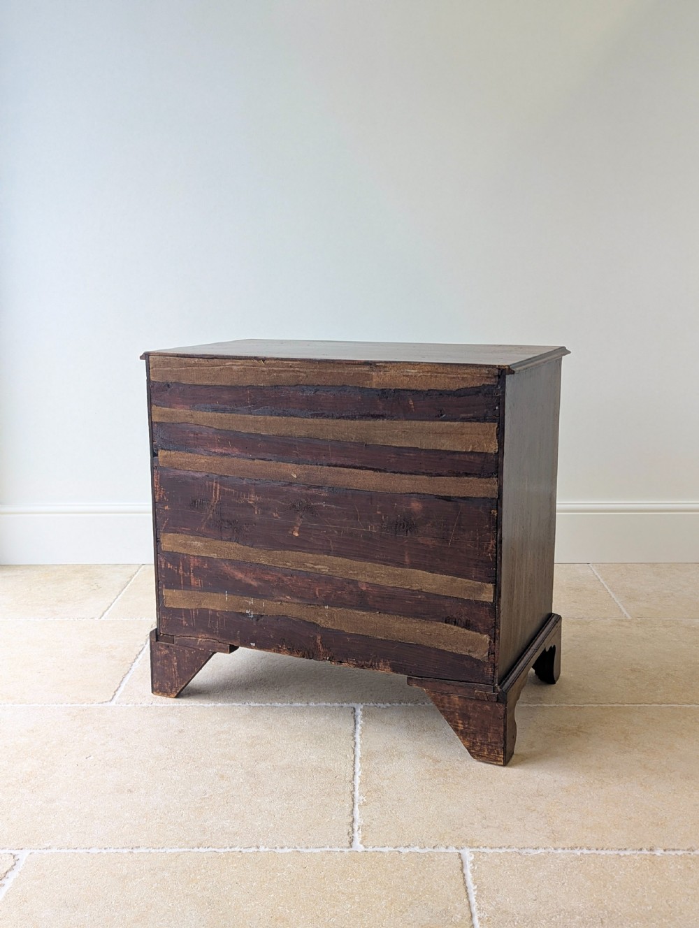 An 18th-century George III mahogany chest of drawers featuring four graduated drawers with brass swan-neck handles and bracket feet. View XVII