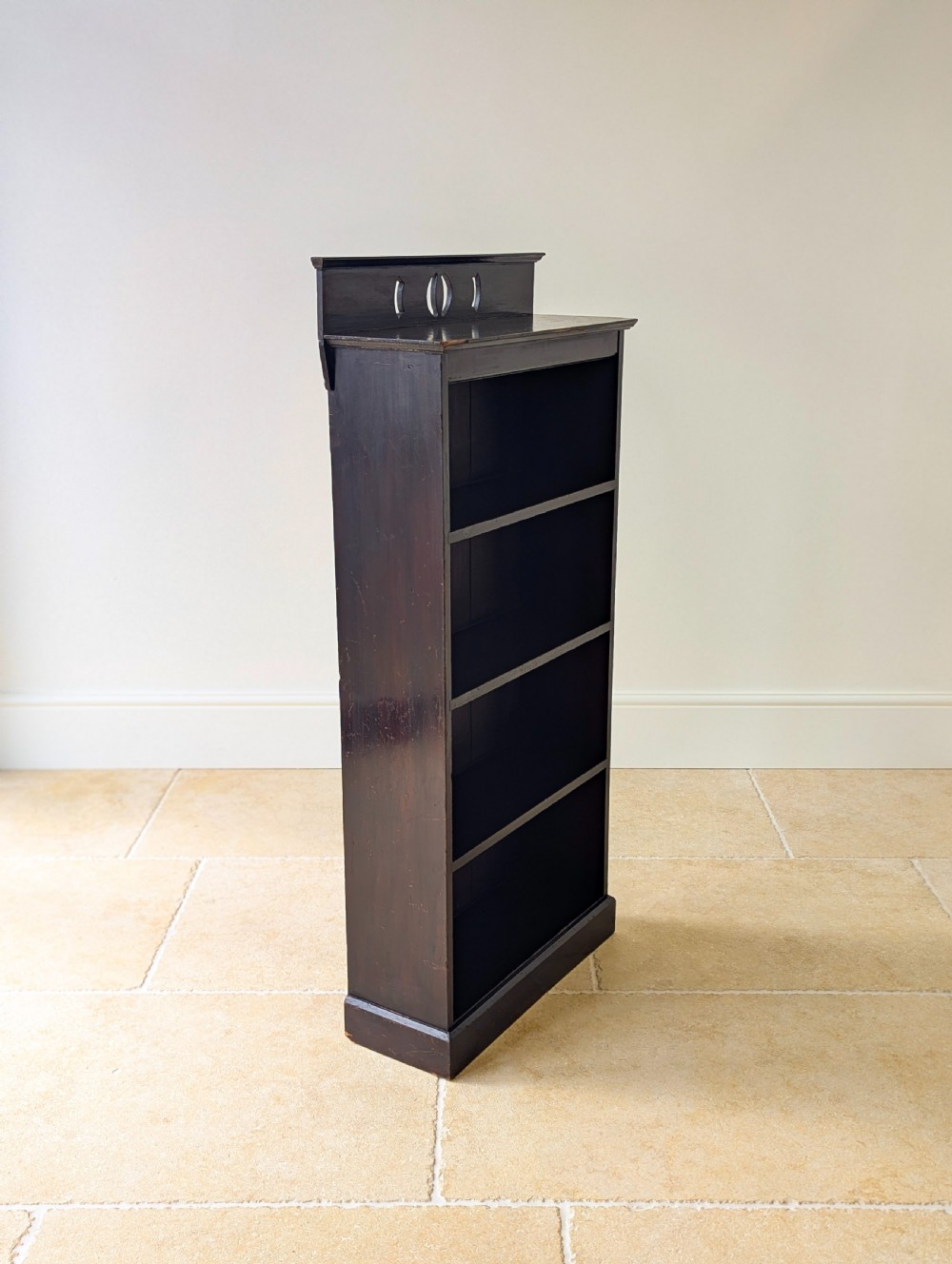 A tall, narrow late Victorian dark stained pine bookcase featuring four open shelves, a planked backboard, and a gallery top with pierced cutouts. View XI