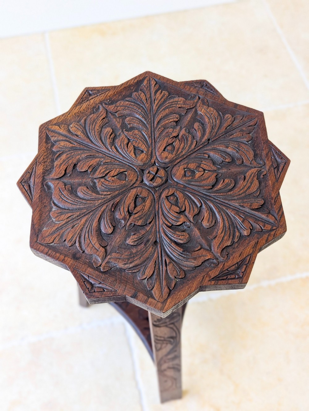 An antique dark oak three-legged occasional table featuring an octagonal carved top and triangular stretcher shelf. View II