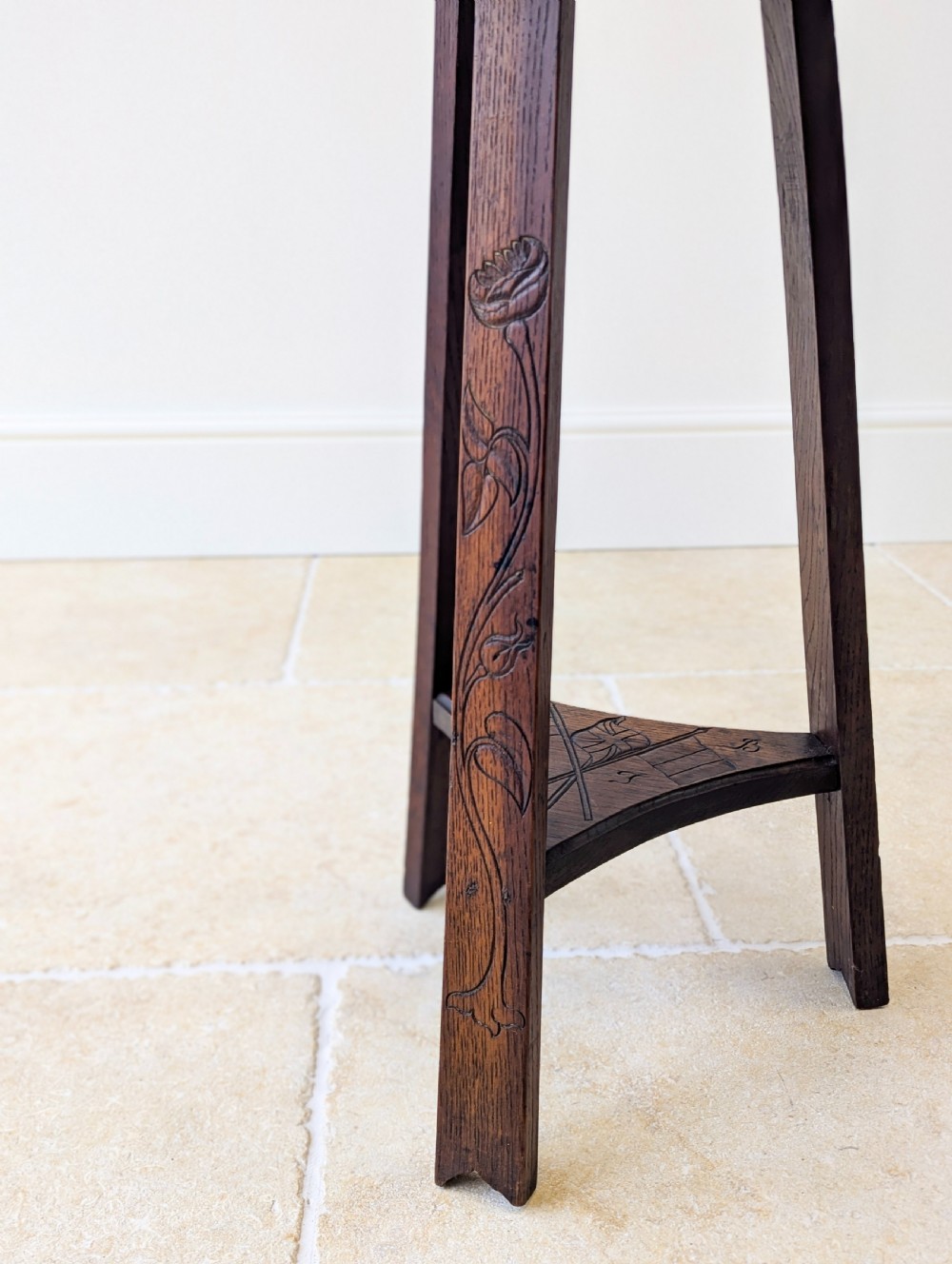 An antique dark oak three-legged occasional table featuring an octagonal carved top and triangular stretcher shelf. View IV