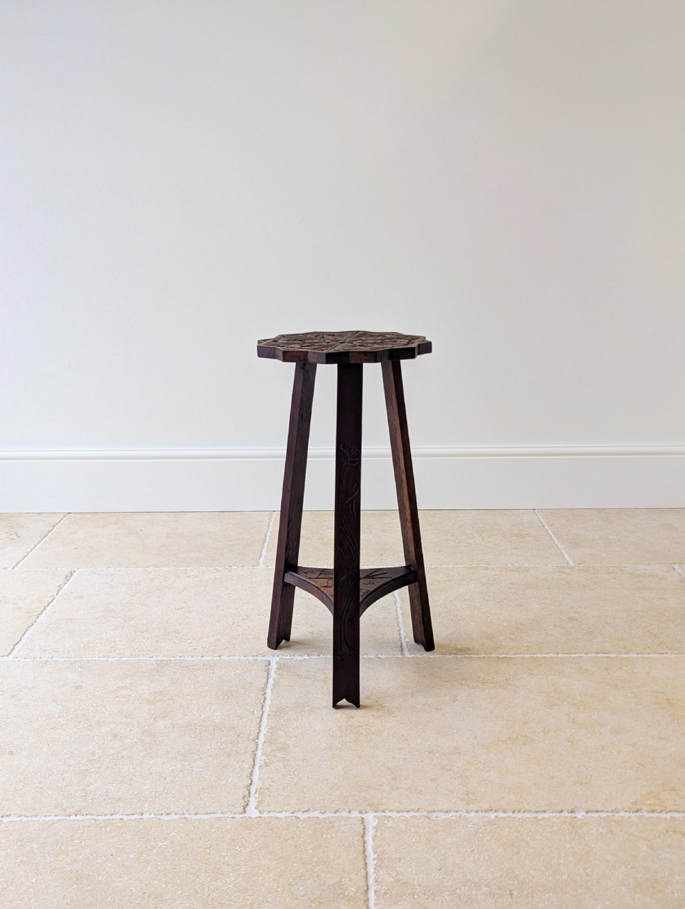 An antique dark oak three-legged occasional table featuring an octagonal carved top and triangular stretcher shelf. View V