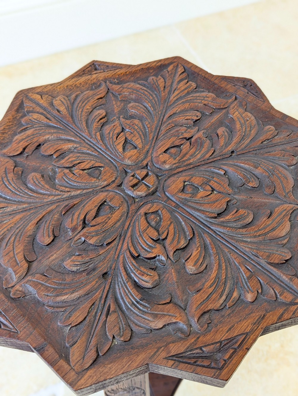 An antique dark oak three-legged occasional table featuring an octagonal carved top and triangular stretcher shelf. View VIII