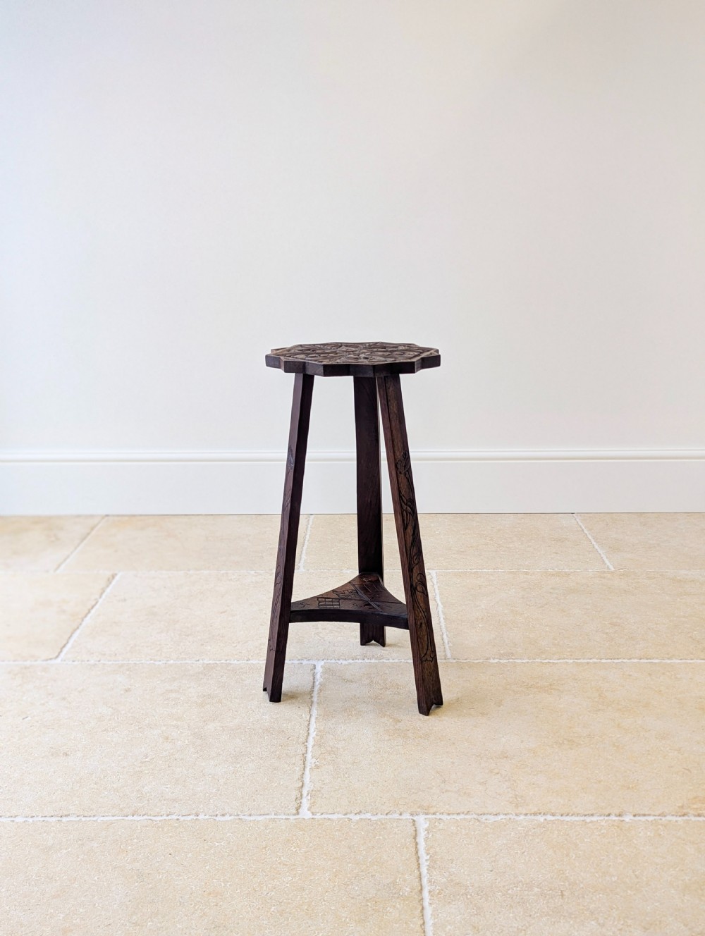 An antique dark oak three-legged occasional table featuring an octagonal carved top and triangular stretcher shelf. View XI