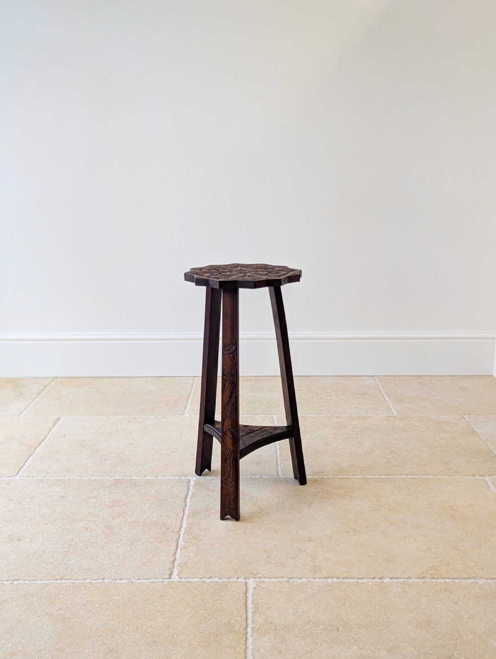 An antique dark oak three-legged occasional table featuring an octagonal carved top and triangular stretcher shelf. View XVI