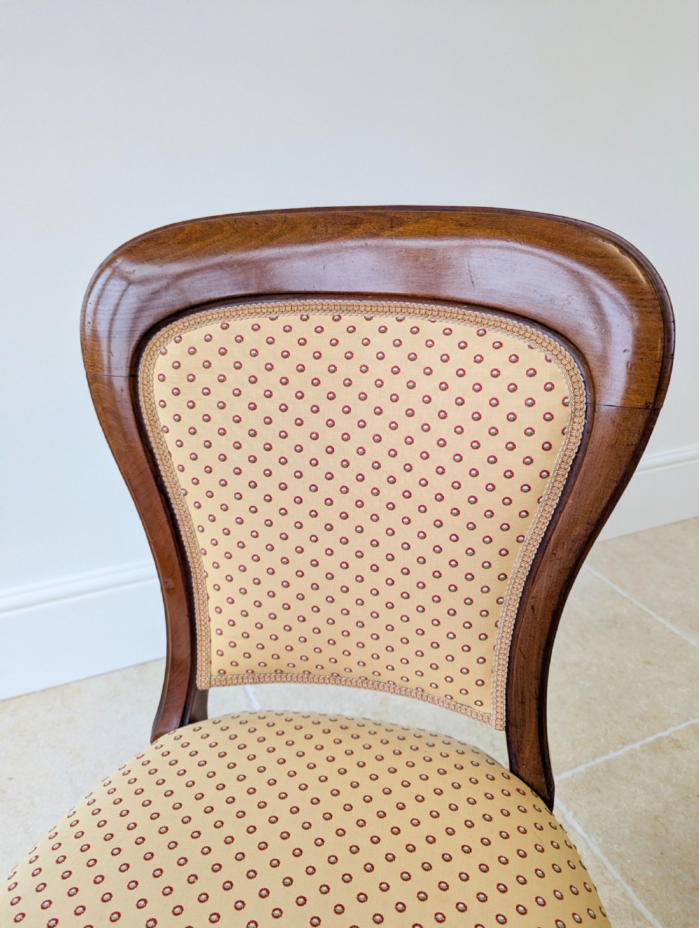 A pair of antique Victorian walnut side chairs with curved backframes, turned front legs, and patterned yellow fabric upholstery. View VIII