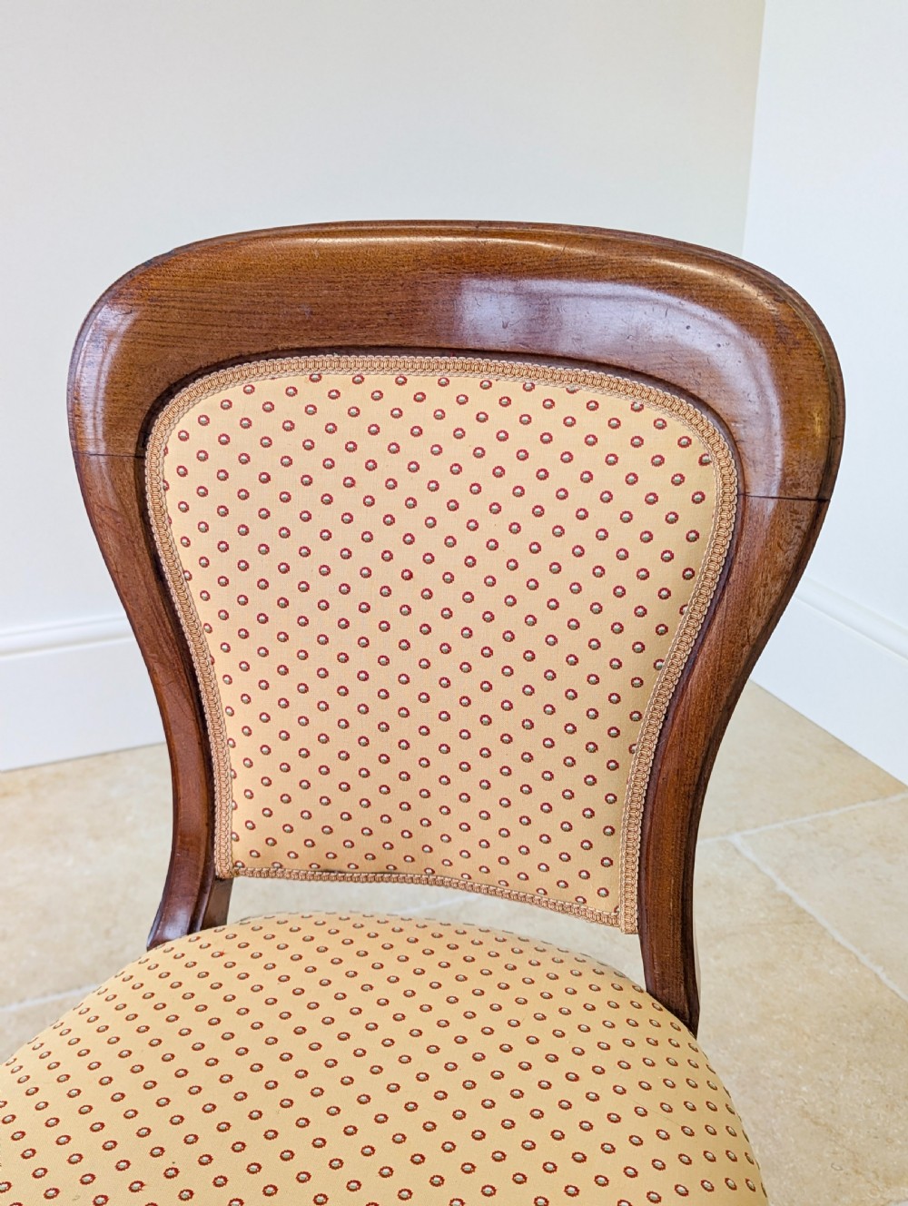A pair of antique Victorian walnut side chairs with curved backframes, turned front legs, and patterned yellow fabric upholstery. View XI