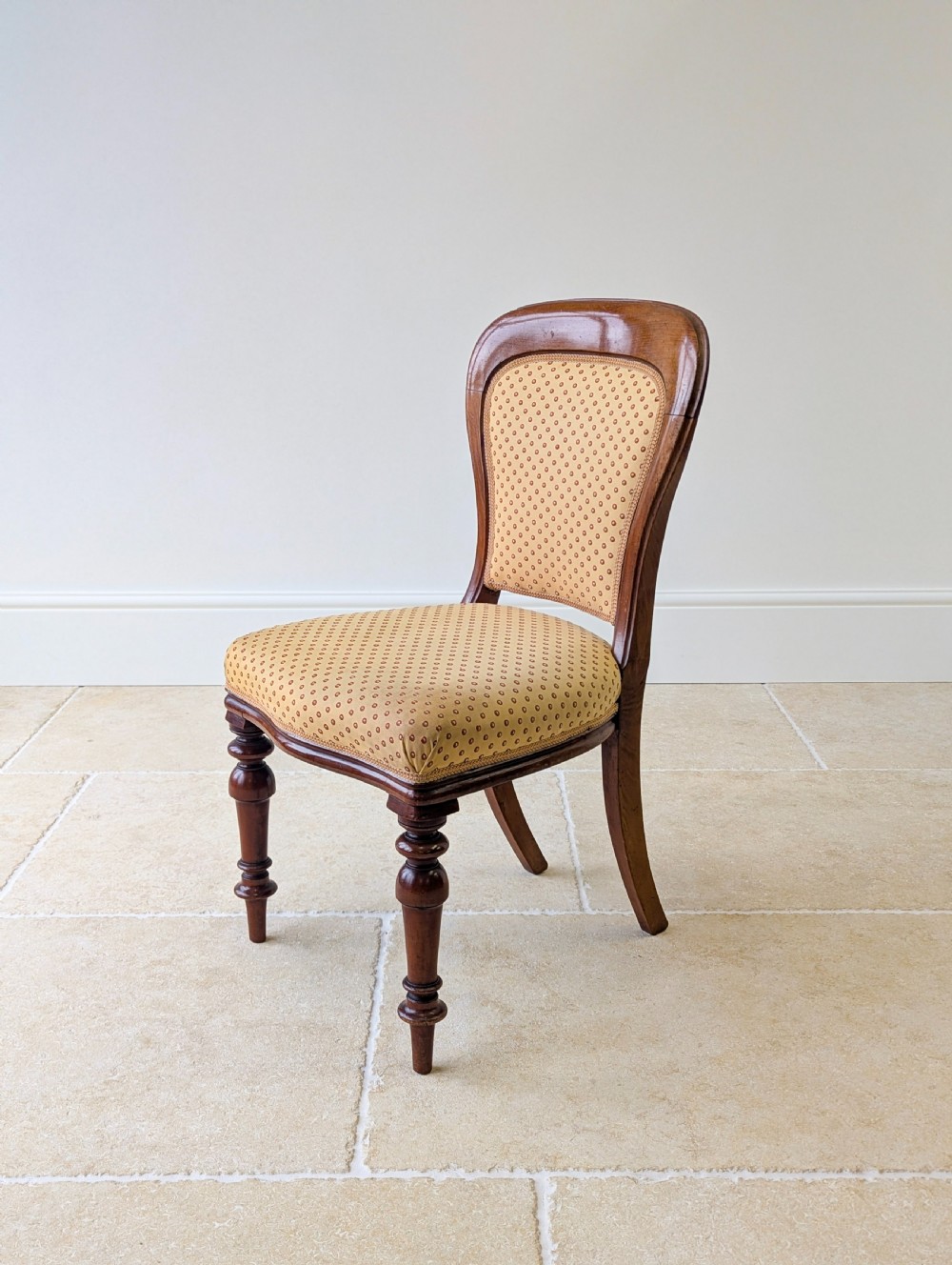 A pair of antique Victorian walnut side chairs with curved backframes, turned front legs, and patterned yellow fabric upholstery. View XIII