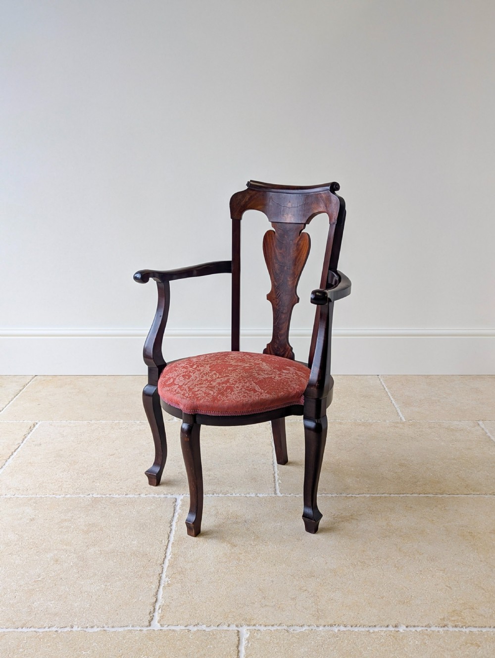 An antique mid-18th century Georgian open armchair crafted from dark mahogany wood featuring a shaped back splat, curved armrests, cabriole front legs, and a red patterned fabric seat. View II