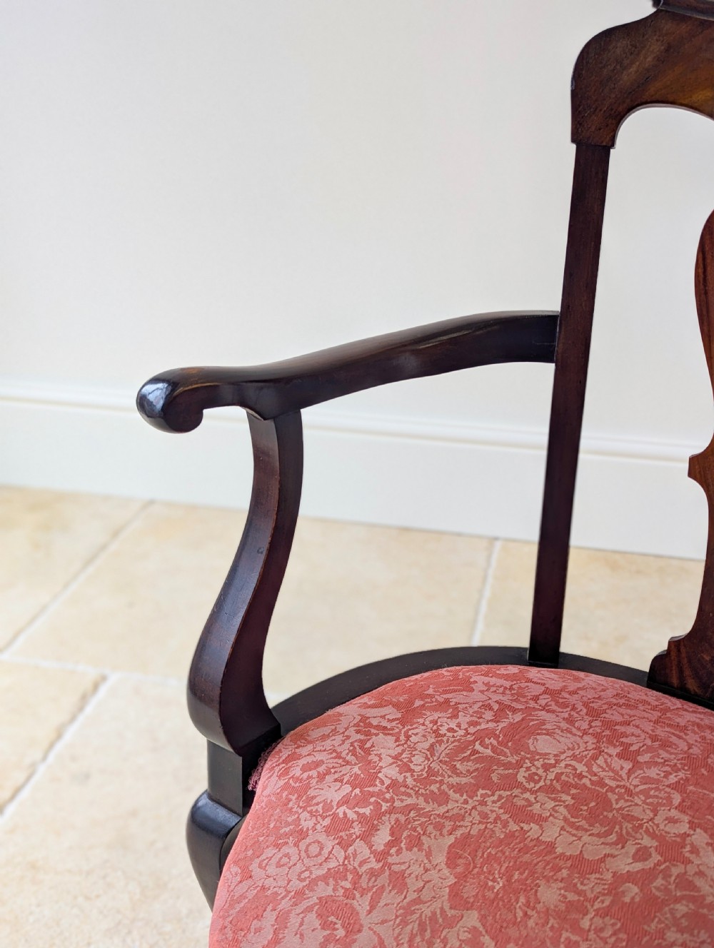 An antique mid-18th century Georgian open armchair crafted from dark mahogany wood featuring a shaped back splat, curved armrests, cabriole front legs, and a red patterned fabric seat. View IV