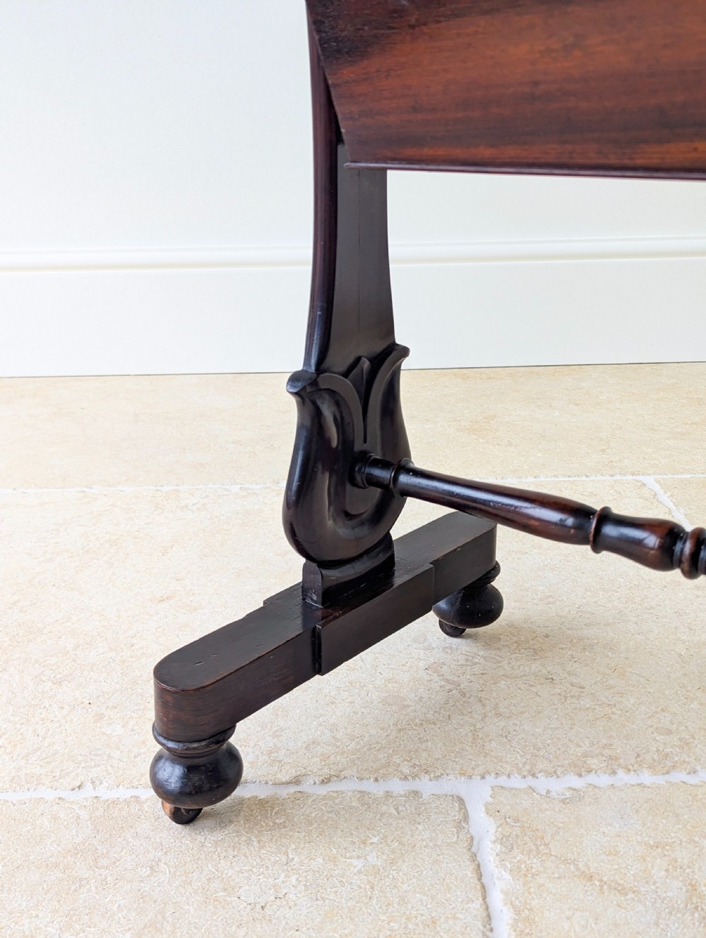 A late 19th-century Victorian mahogany sewing table featuring a top drawer with circular turned wooden handles over a deep tapered work bin, raised on scrolled lyre side supports, a turned stretcher, and castors. View IX