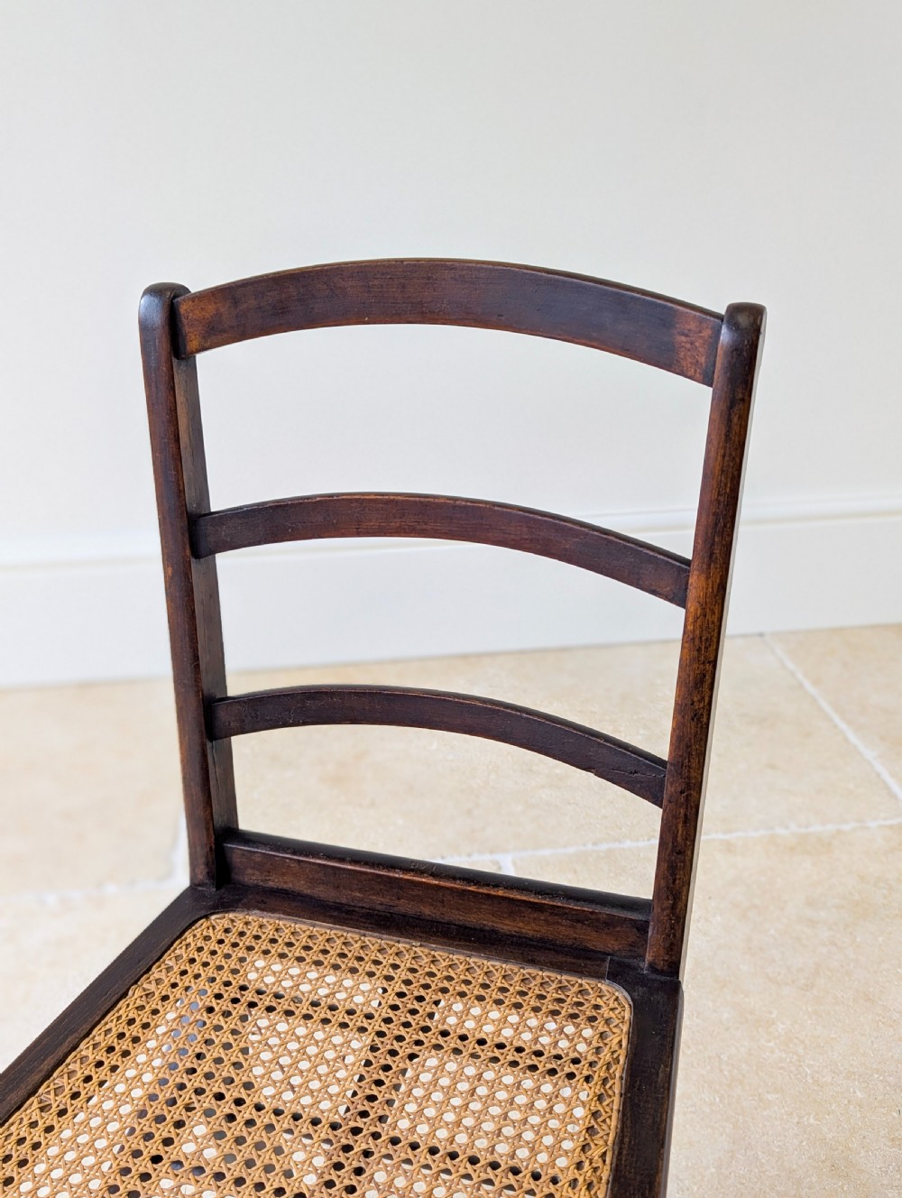 A Victorian dark wood folding campaign chair featuring a triple ladder back, a woven cane seat, and hinged folding legs. View XI