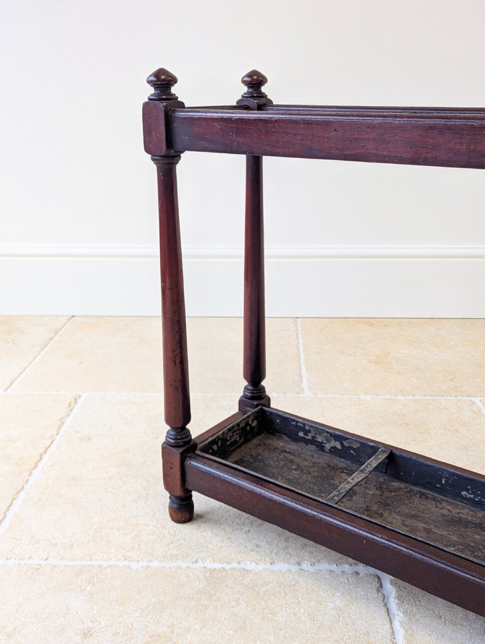 A Victorian dark mahogany stick stand featuring four turned corner supports, a partitioned upper frame, and a metal drip tray base. View V