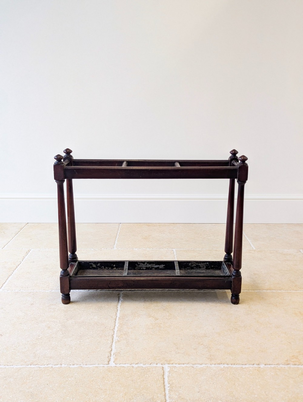 A Victorian dark mahogany stick stand featuring four turned corner supports, a partitioned upper frame, and a metal drip tray base. View VIII