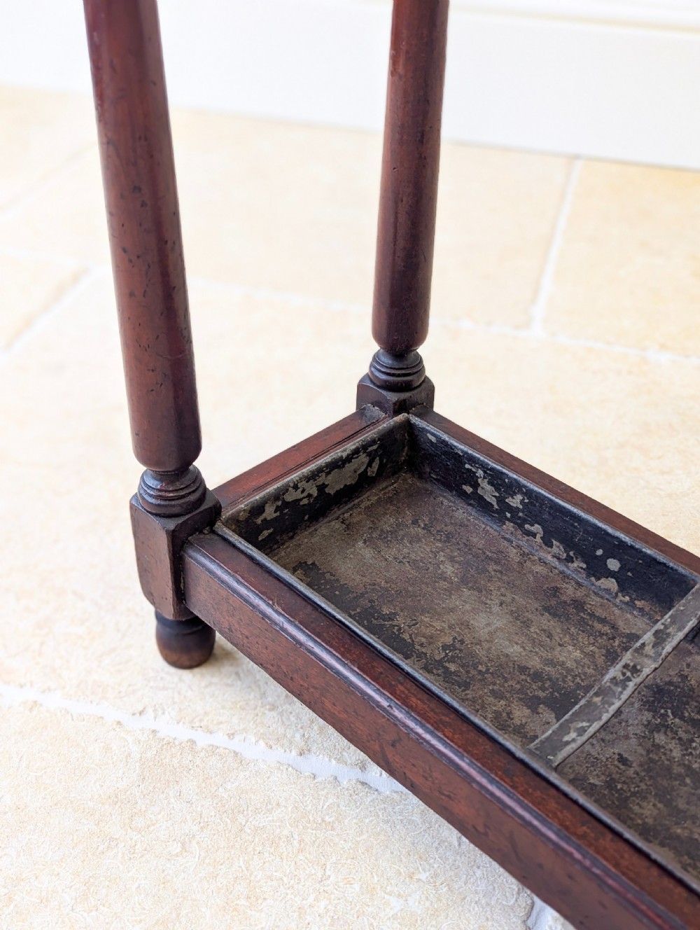 A Victorian dark mahogany stick stand featuring four turned corner supports, a partitioned upper frame, and a metal drip tray base. View XIII