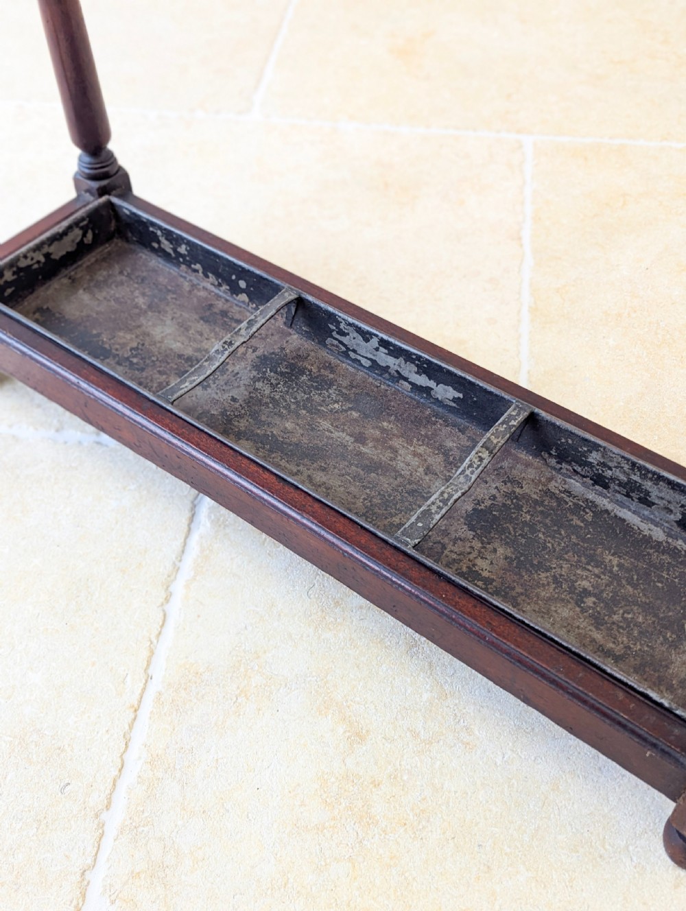 A Victorian dark mahogany stick stand featuring four turned corner supports, a partitioned upper frame, and a metal drip tray base. View XVIII
