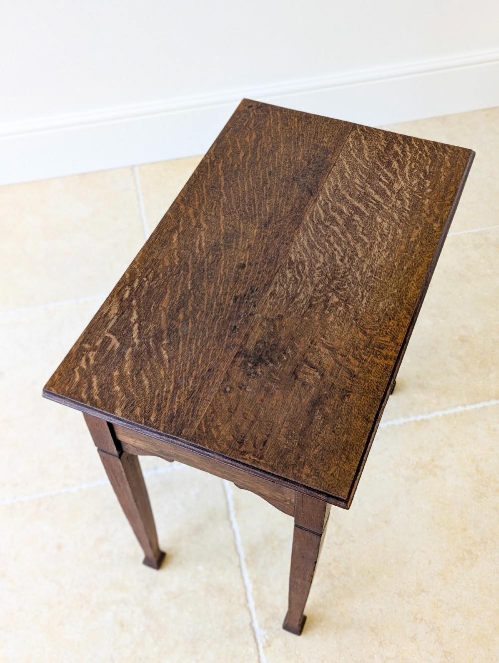 An antique dark oak side table featuring a single drawer with brass drop handles, shaped corner aprons, and slender tapered legs. View IV