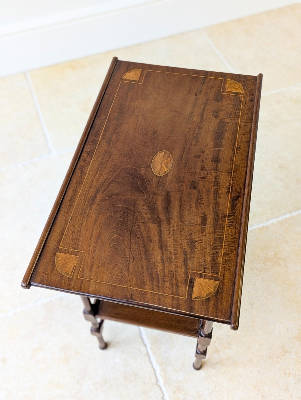 An Edwardian mahogany Anglo-Japanese occasional table with a pagoda-style top, carved scroll apron, and tiered display shelves on turned legs. View III