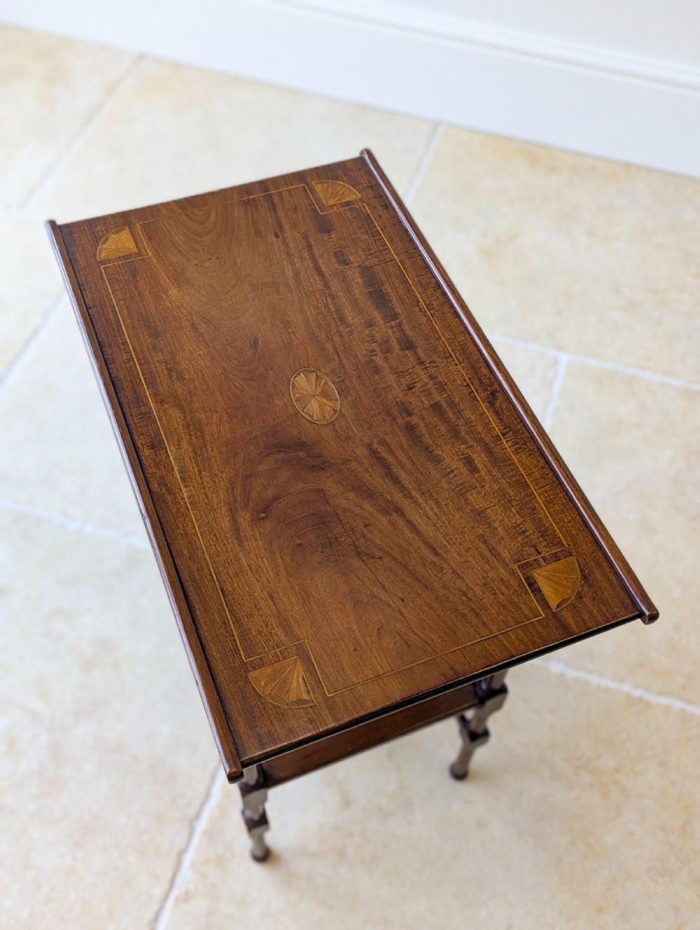 An Edwardian mahogany Anglo-Japanese occasional table with a pagoda-style top, carved scroll apron, and tiered display shelves on turned legs. View XII
