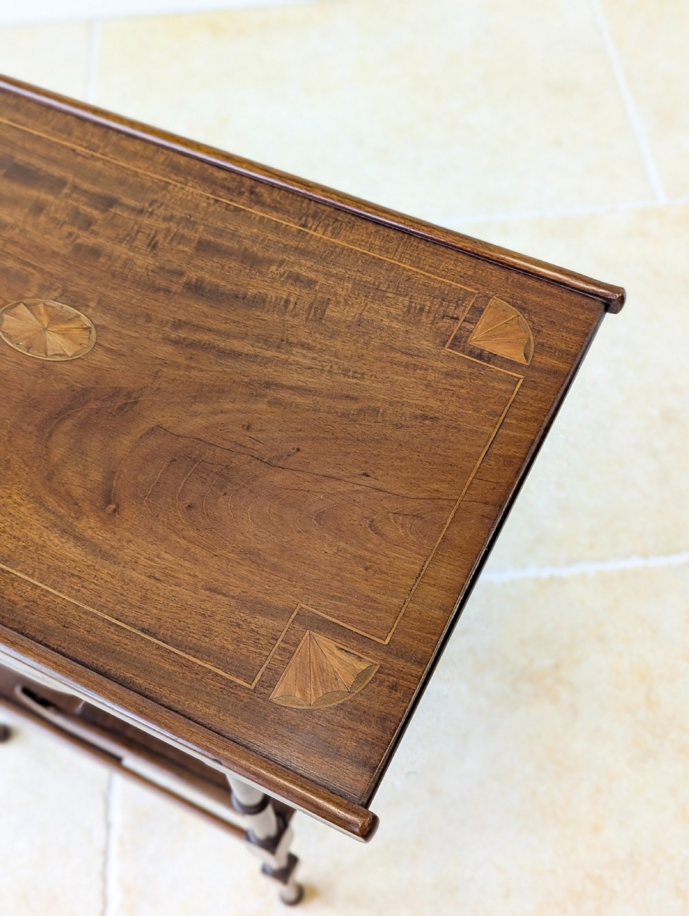 An Edwardian mahogany Anglo-Japanese occasional table with a pagoda-style top, carved scroll apron, and tiered display shelves on turned legs. View XV