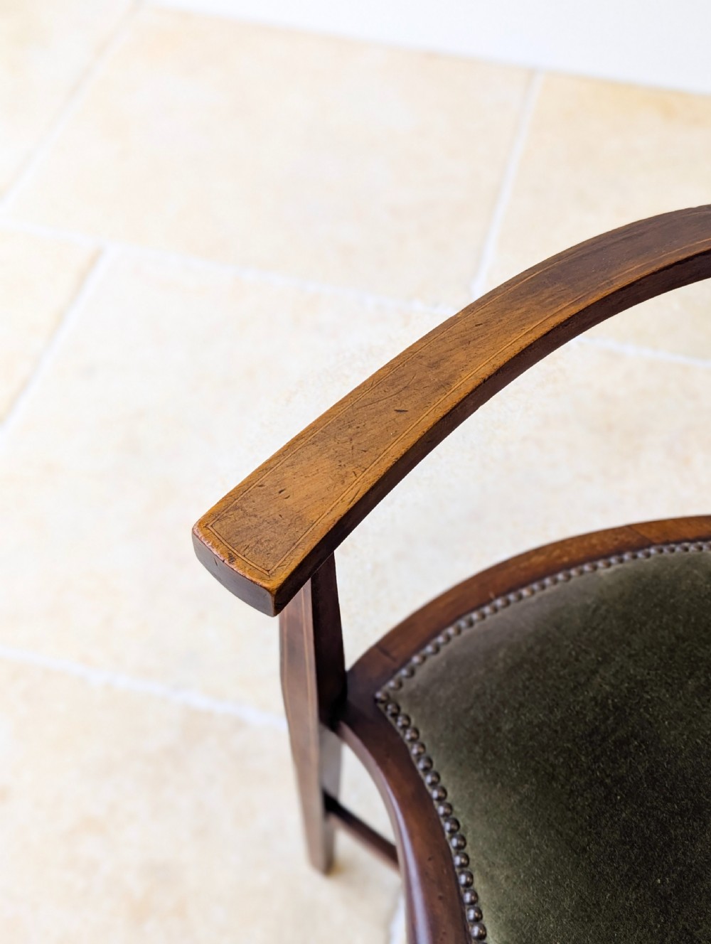 An Edwardian mahogany elbow chair featuring a high pierced back splat, swept arms, and an olive green velvet upholstered seat. View XI