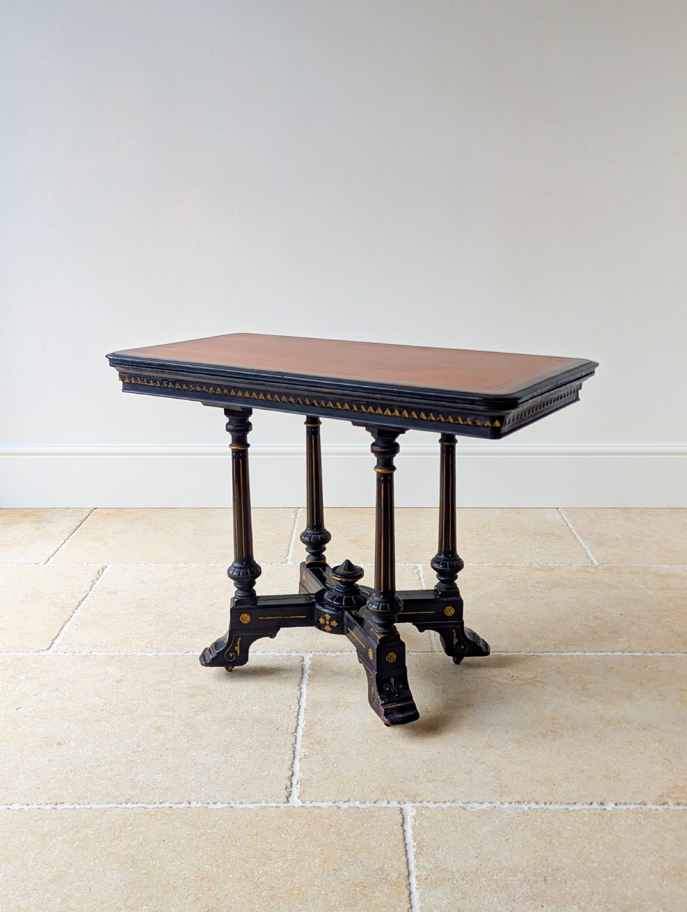 An antique Victorian ebonised and gilt card table with turned twin pedestals and a central finial stretcher. View V