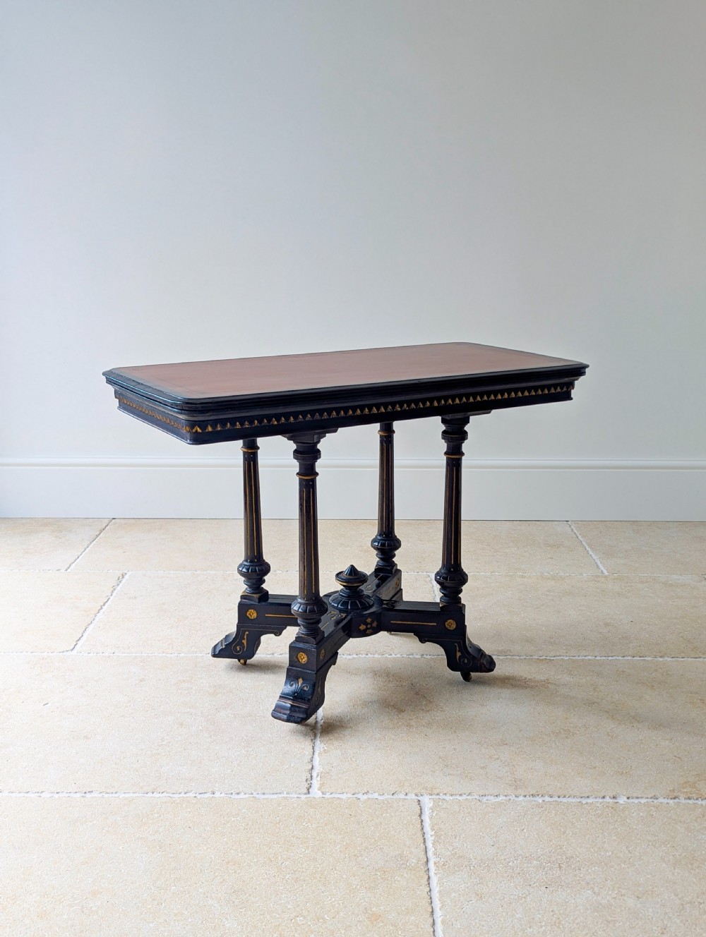 An antique Victorian ebonised and gilt card table with turned twin pedestals and a central finial stretcher. View XII