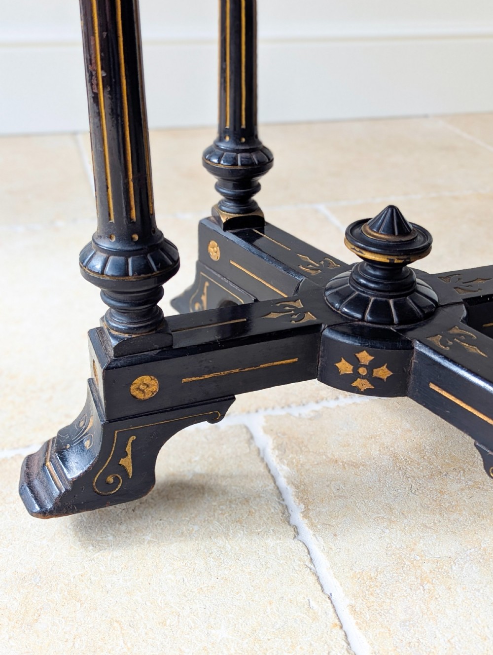 An antique Victorian ebonised and gilt card table with turned twin pedestals and a central finial stretcher. View XVI