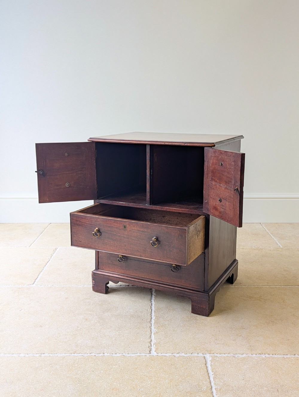 A dark mahogany Georgian commode chest with faux upper drawer fronts, two lower drawers, brass drop handles, and bracket feet. View II