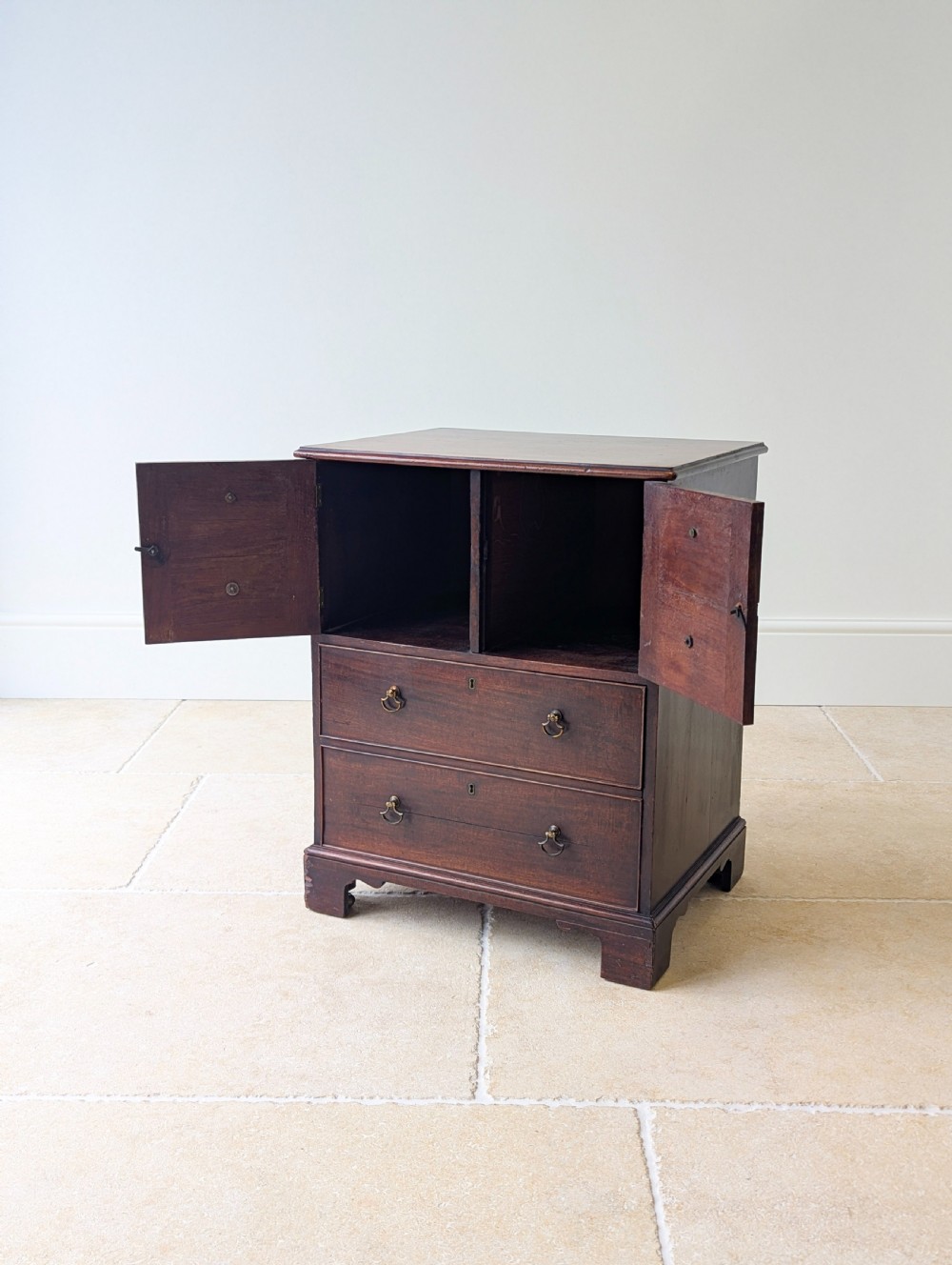 A dark mahogany Georgian commode chest with faux upper drawer fronts, two lower drawers, brass drop handles, and bracket feet. View VII
