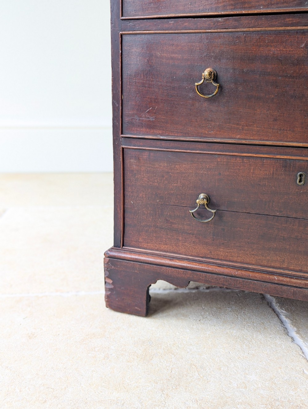 A dark mahogany Georgian commode chest with faux upper drawer fronts, two lower drawers, brass drop handles, and bracket feet. View VIII