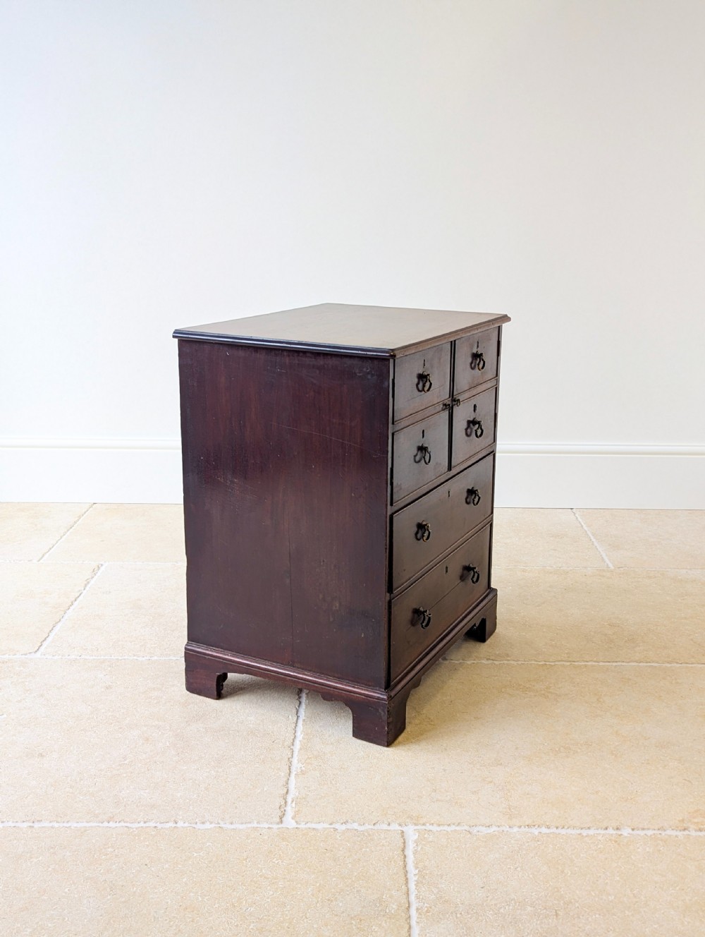 A dark mahogany Georgian commode chest with faux upper drawer fronts, two lower drawers, brass drop handles, and bracket feet. View XII