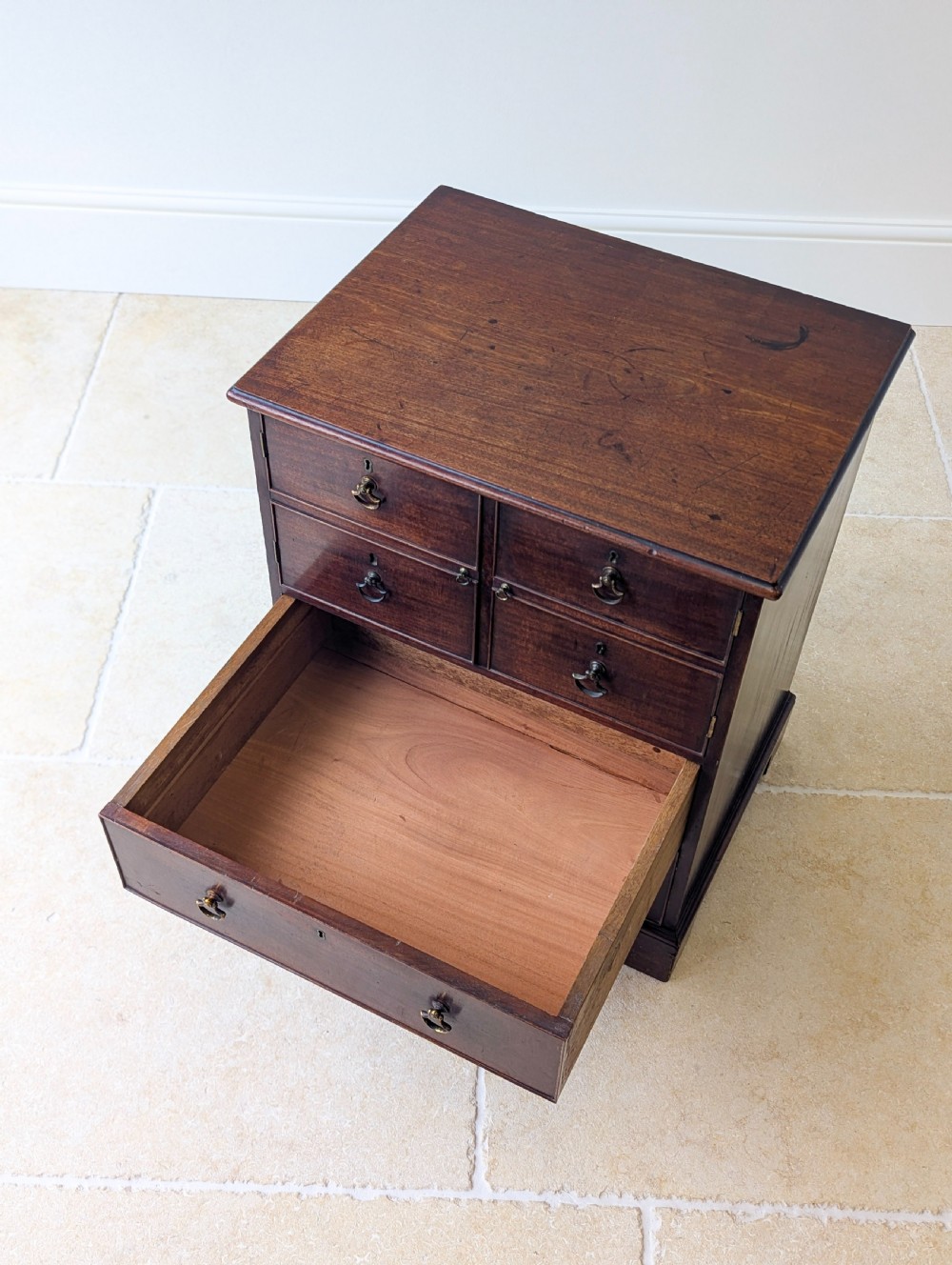 A dark mahogany Georgian commode chest with faux upper drawer fronts, two lower drawers, brass drop handles, and bracket feet. View XIV