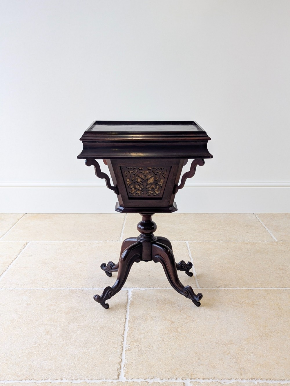 A dark brown rosewood Victorian sewing and reading table featuring an adjustable slanted lid with brass page holders, carved fretwork sides, a turned pedestal column, and four scrolled feet. View II