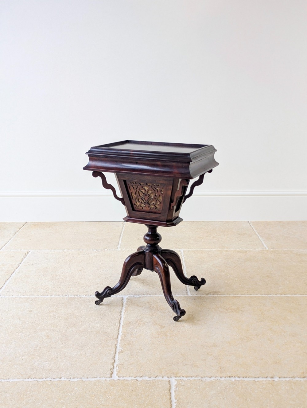 A dark brown rosewood Victorian sewing and reading table featuring an adjustable slanted lid with brass page holders, carved fretwork sides, a turned pedestal column, and four scrolled feet. View V
