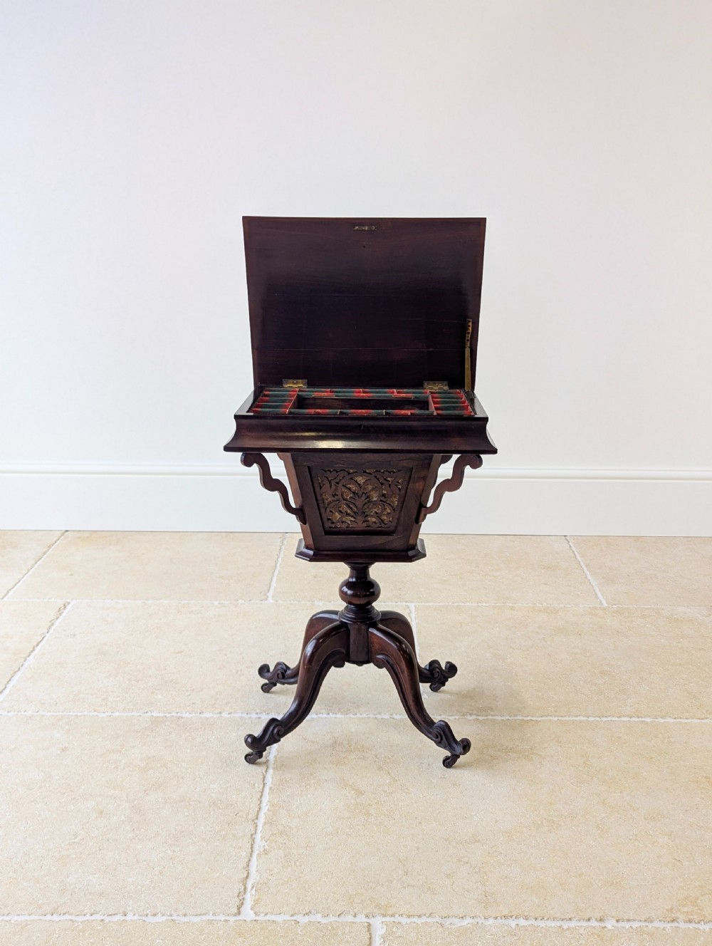 A dark brown rosewood Victorian sewing and reading table featuring an adjustable slanted lid with brass page holders, carved fretwork sides, a turned pedestal column, and four scrolled feet. View VII