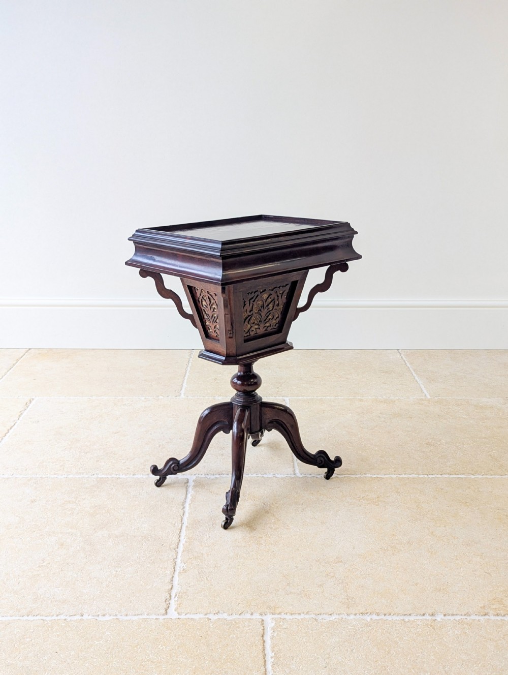 A dark brown rosewood Victorian sewing and reading table featuring an adjustable slanted lid with brass page holders, carved fretwork sides, a turned pedestal column, and four scrolled feet. View XIII