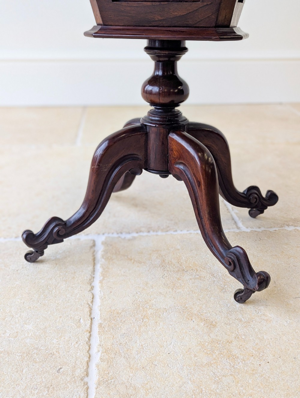 A dark brown rosewood Victorian sewing and reading table featuring an adjustable slanted lid with brass page holders, carved fretwork sides, a turned pedestal column, and four scrolled feet. View XIV