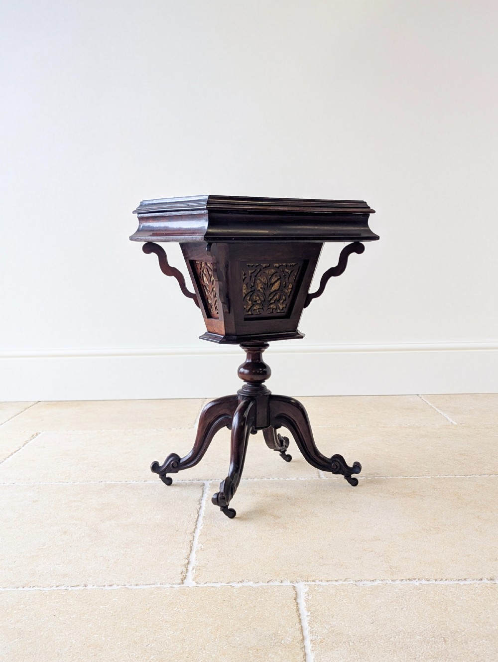 A dark brown rosewood Victorian sewing and reading table featuring an adjustable slanted lid with brass page holders, carved fretwork sides, a turned pedestal column, and four scrolled feet. View XIX