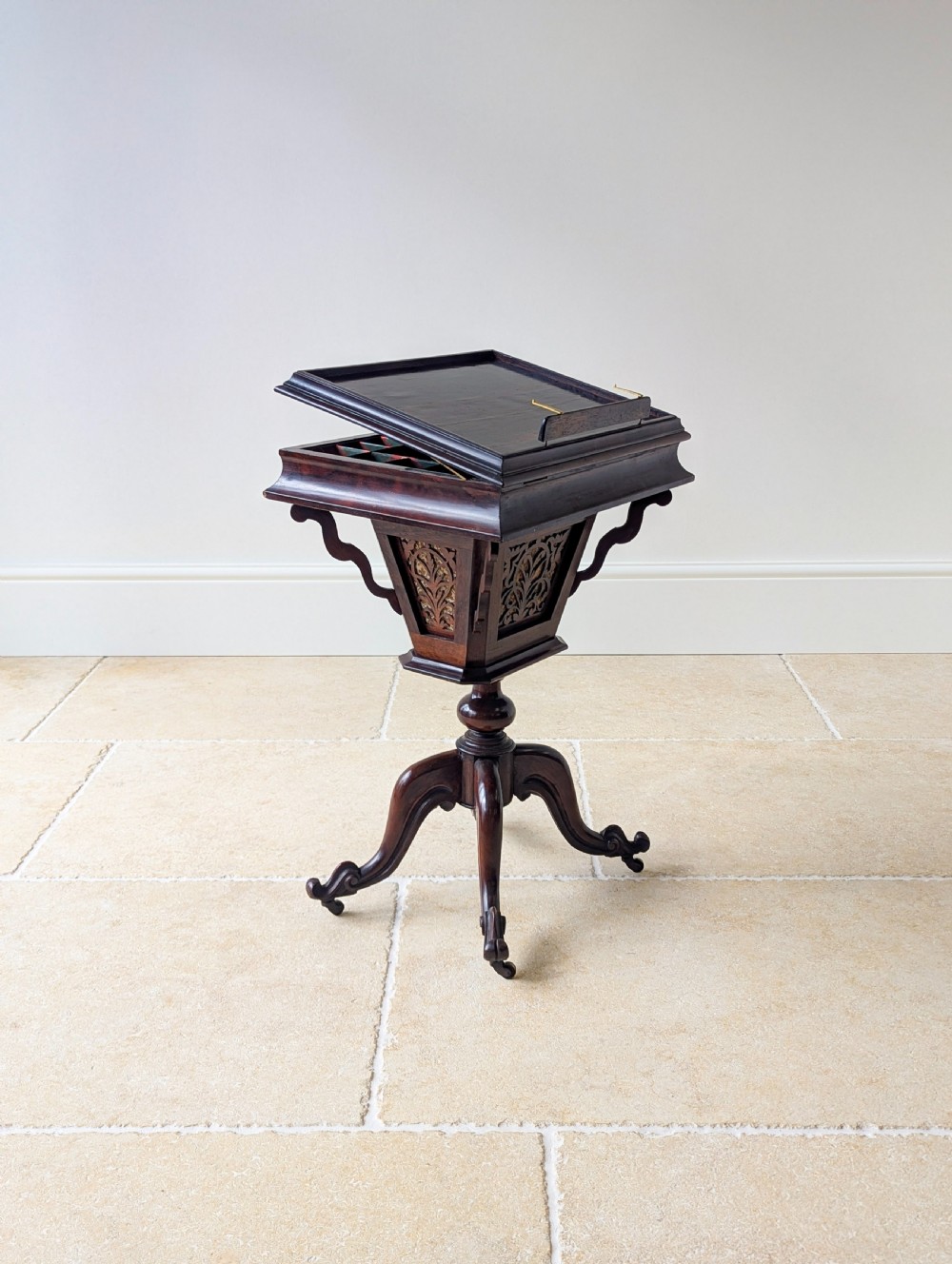 A dark brown rosewood Victorian sewing and reading table featuring an adjustable slanted lid with brass page holders, carved fretwork sides, a turned pedestal column, and four scrolled feet. View XX