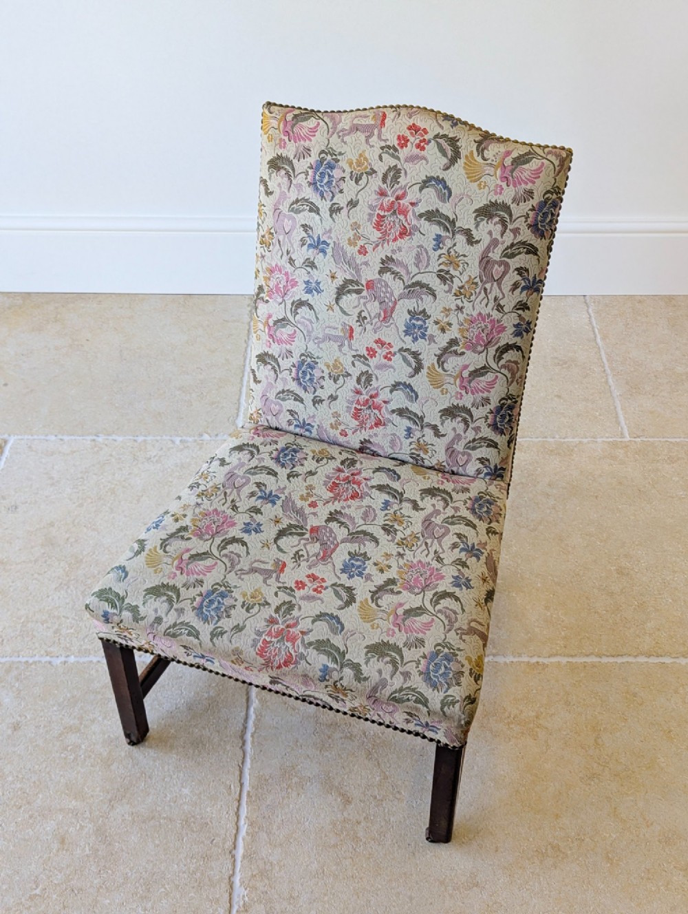A mid-19th century Victorian side chair with dark mahogany legs on brass castors and dense floral upholstery framed with brass studding. View II