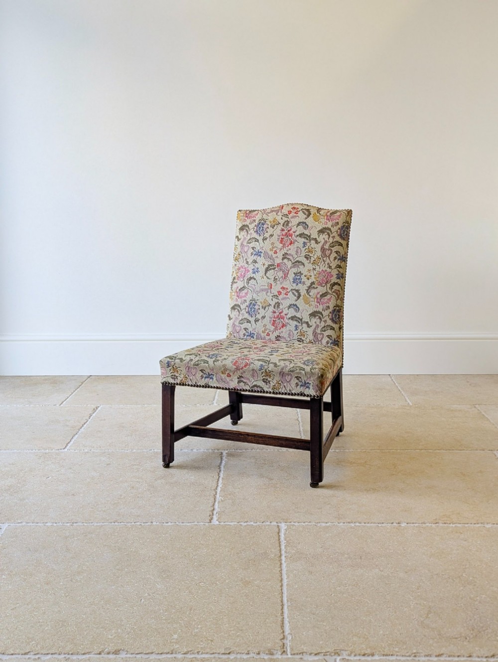 A mid-19th century Victorian side chair with dark mahogany legs on brass castors and dense floral upholstery framed with brass studding. View VIII