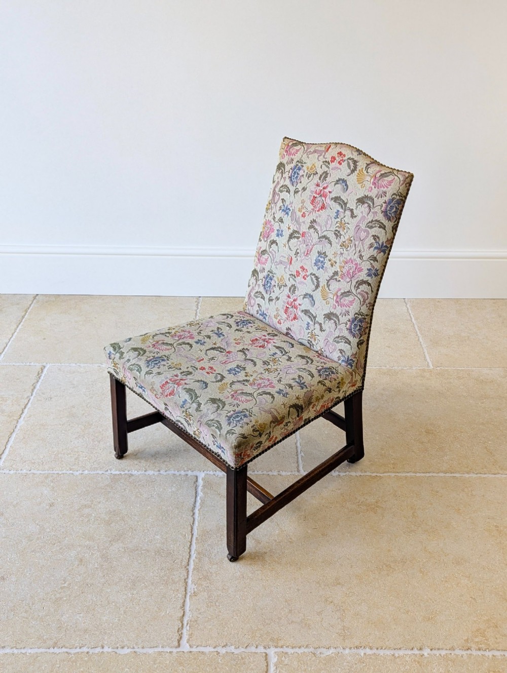 A mid-19th century Victorian side chair with dark mahogany legs on brass castors and dense floral upholstery framed with brass studding. View X