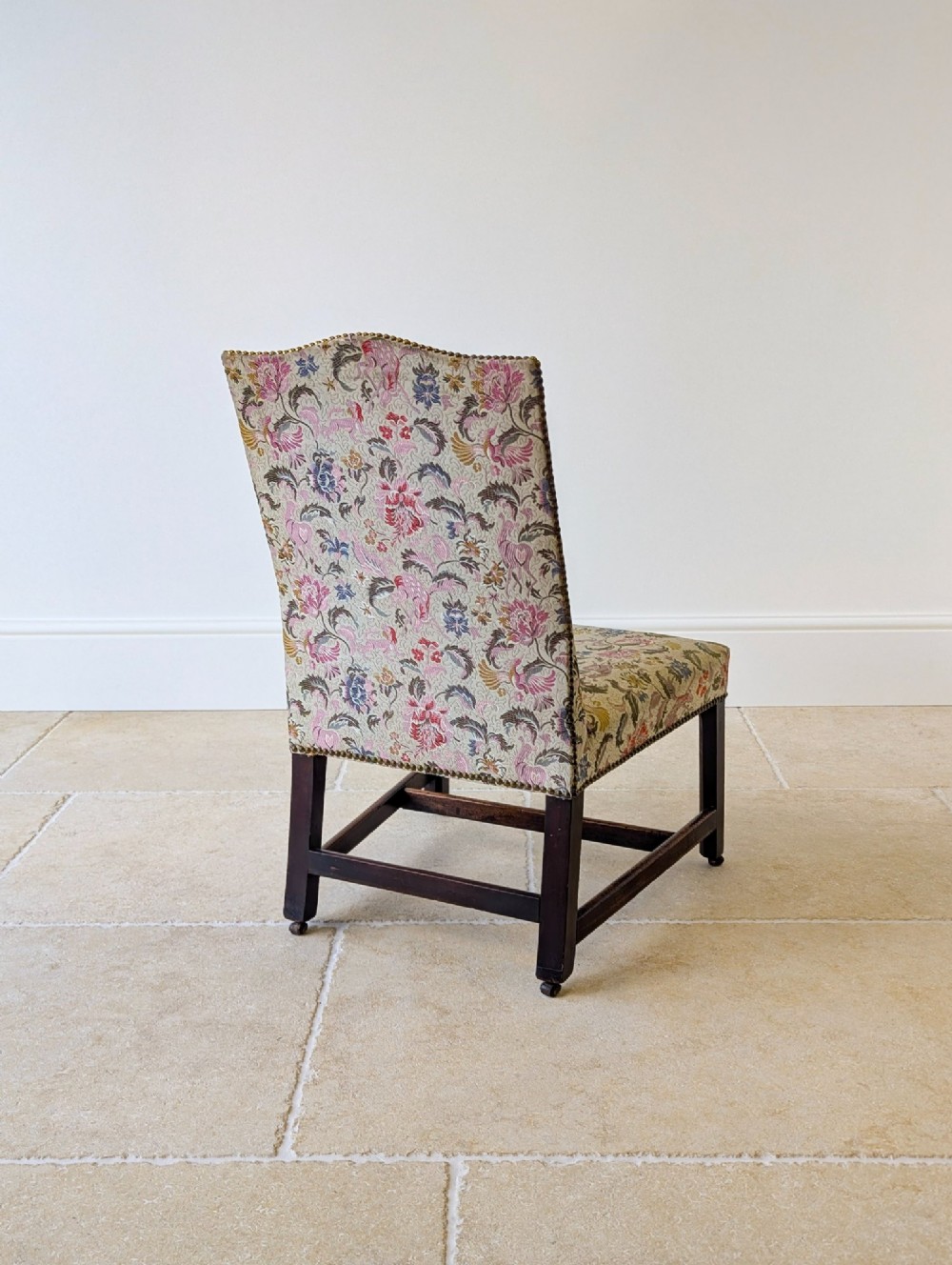 A mid-19th century Victorian side chair with dark mahogany legs on brass castors and dense floral upholstery framed with brass studding. View XIV