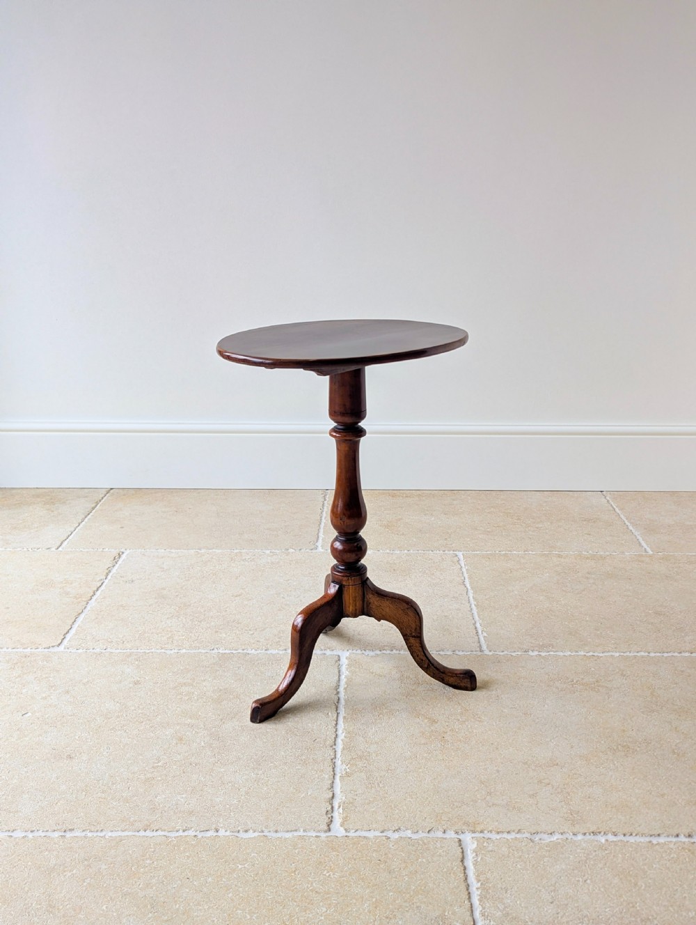 An antique Georgian mahogany wine table featuring a smooth oval top, turned central column, and three cabriole tripod legs. View XI