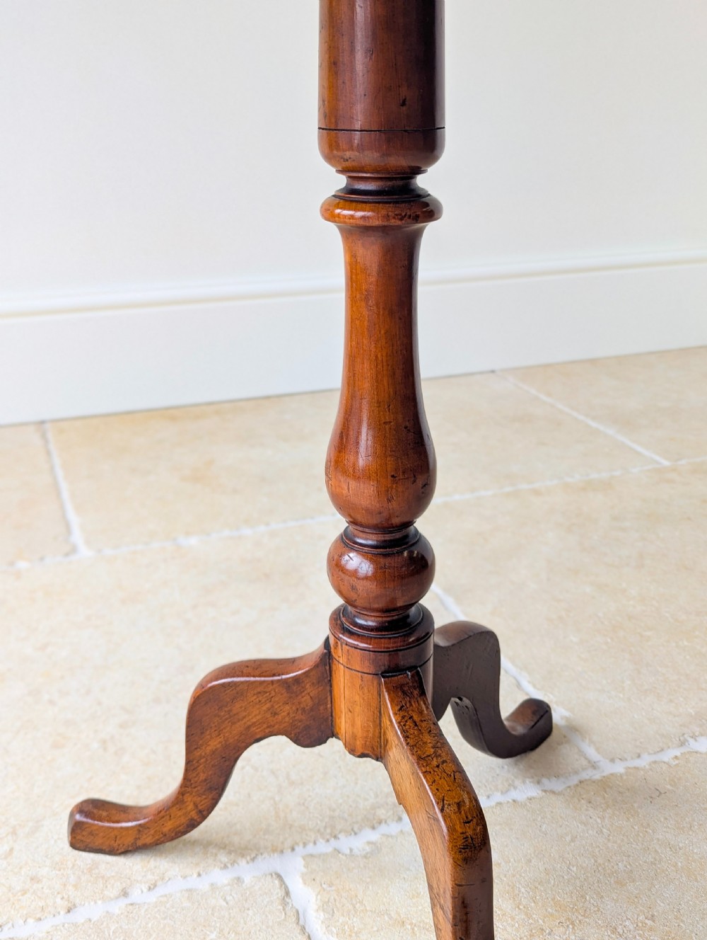 An antique Georgian mahogany wine table featuring a smooth oval top, turned central column, and three cabriole tripod legs. View XII