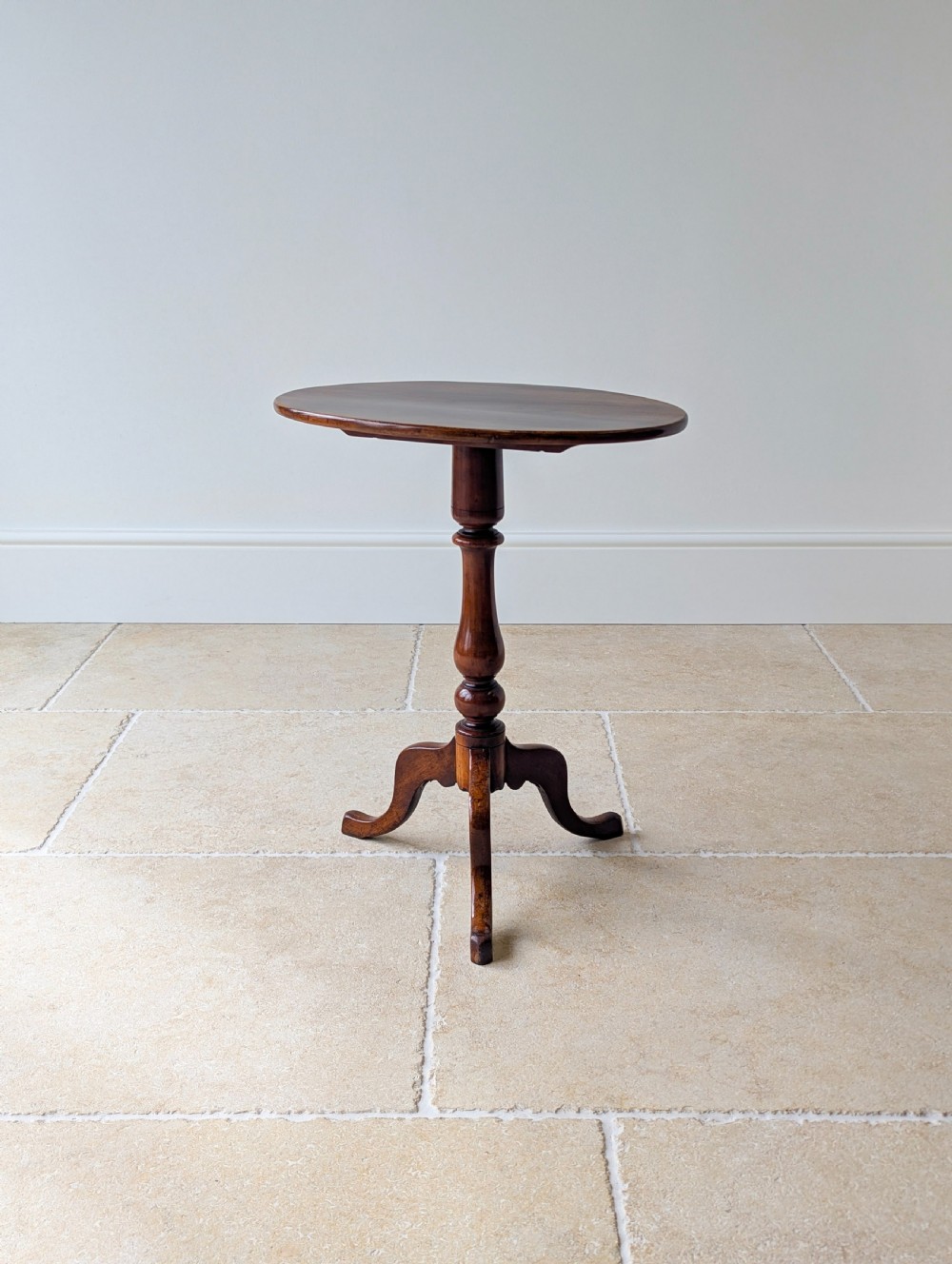 An antique Georgian mahogany wine table featuring a smooth oval top, turned central column, and three cabriole tripod legs. View XIII