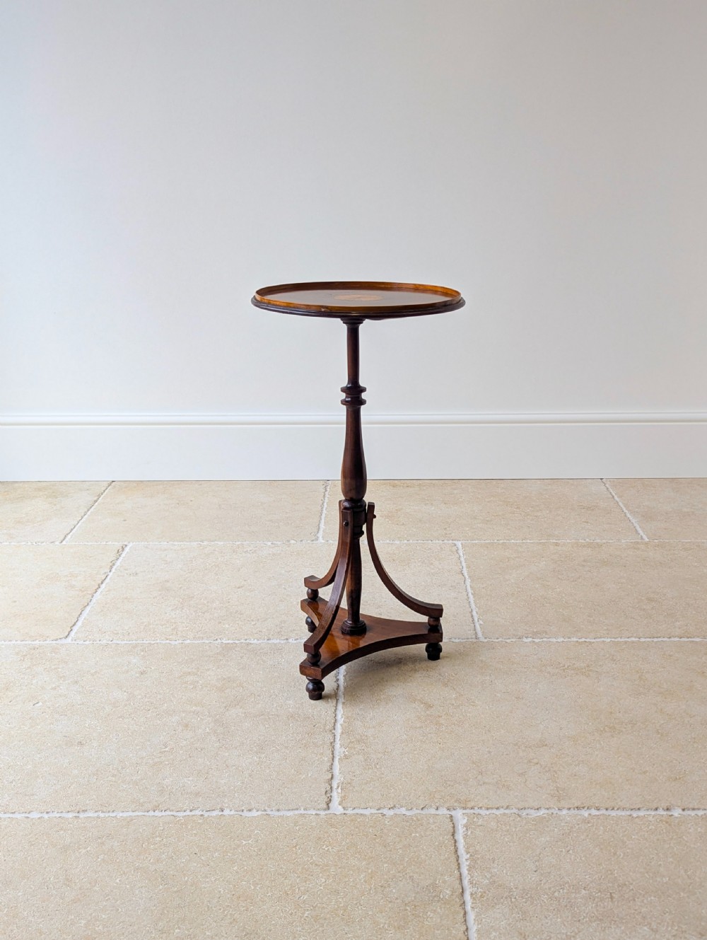 An Edwardian mahogany wine table featuring a circular top with a raised moulded edge, supported by a turned pedestal column and a triform base on small bun feet. View XIII
