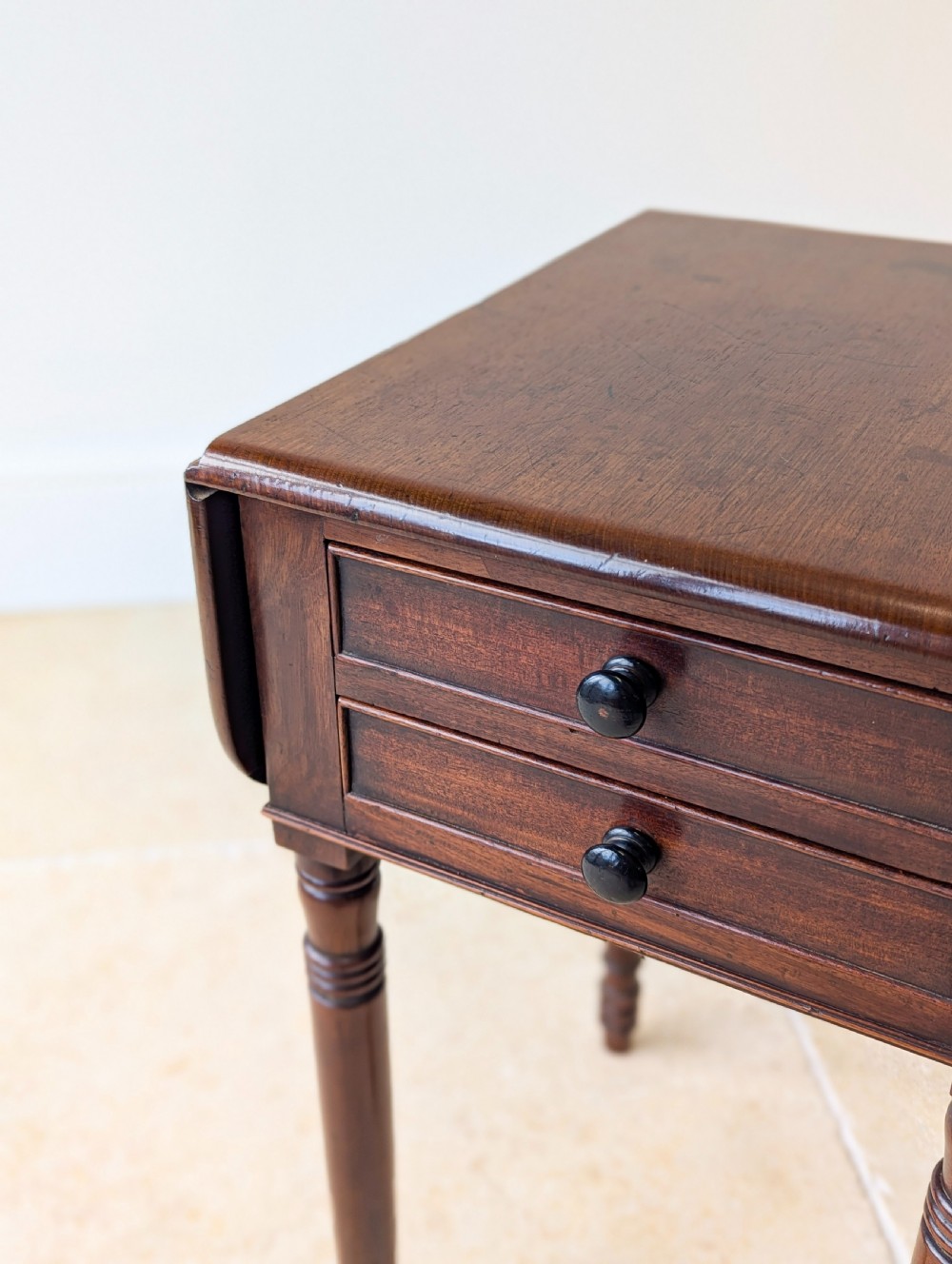 An early Victorian dark mahogany Pembroke work table with two drawers, turned legs, and two extended drop-leaf flaps. View VI
