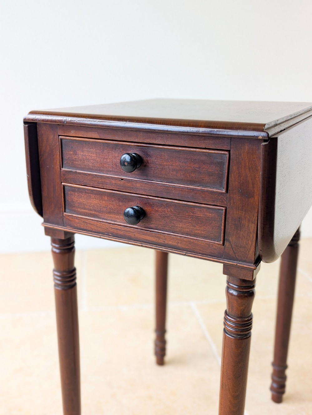 An early Victorian dark mahogany Pembroke work table with two drawers, turned legs, and two extended drop-leaf flaps. View X